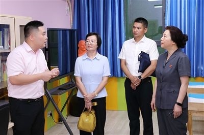 圖③：“小公民法律課堂”開講前，全國人大代表殷其龍（右二）、重慶市人大代表李自玲（左二）聽取楊家坪中學負責人關(guān)于未成年人思想教育工作情況的介紹。