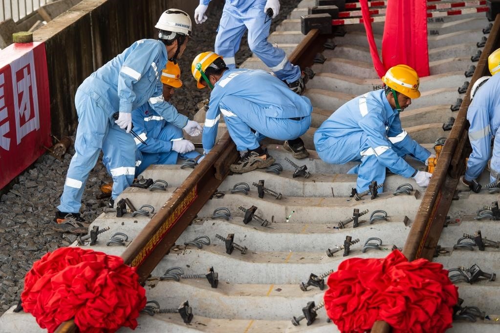 3月31日，在印度尼西亞雅加達雅萬高鐵哈利姆車站，工人鋪設(shè)雅萬高鐵全線最后一根鋼軌。