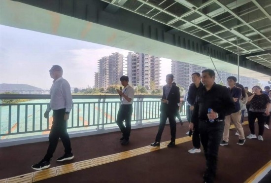 10月24日，2023“一帶一路”媒體合作論壇聯(lián)合采訪(fǎng)團(tuán)團(tuán)員走在清水塘大橋景觀通道上。本報(bào)記者 常雯宜攝