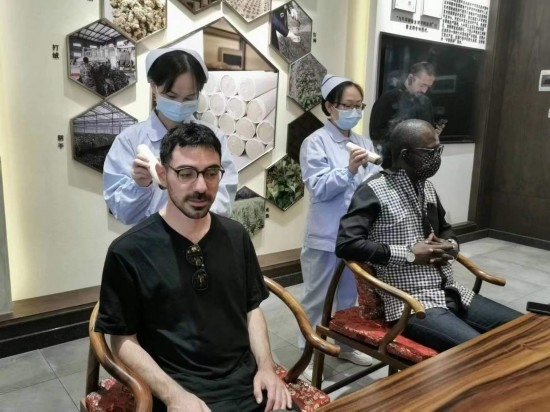 2023“一帶一路”媒體合作論壇聯(lián)合采訪團(tuán)團(tuán)員在九牛草展示館體驗(yàn)艾灸。（本報記者 黃超攝）