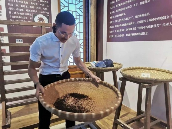 2023“一帶一路”媒體合作論壇聯(lián)合采訪團(tuán)團(tuán)員在非遺文化展示館體驗(yàn)中藥炮制技藝。（本報記者 黃超攝）