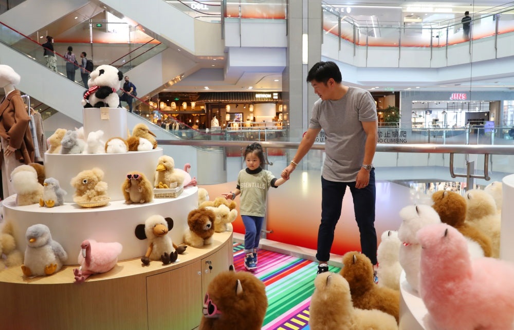 2023年11月2日，顧客在溫暖駝品牌專柜內(nèi)選購。連續(xù)六年參加進(jìn)博會(huì)的秘魯羊駝制品品牌溫暖駝在上海市中心商場開設(shè)了專柜。新華社記者 方喆 攝