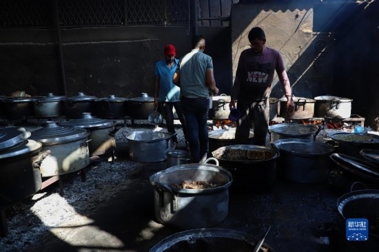 11月3日，在加沙地帶南部城市拉法，人們?cè)诿簹庵袛嗪笥貌窕鹱鲲?。新華社發(fā)（里澤克·阿卜杜勒賈瓦德攝）