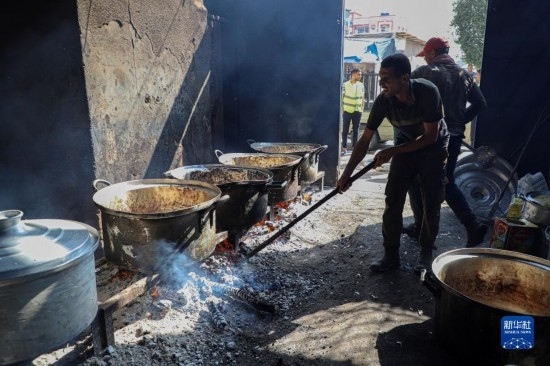 11月3日，在加沙地帶南部城市拉法，人們?cè)诿簹庵袛嗪笥貌窕鹱鲲?。新華社發(fā)（里澤克·阿卜杜勒賈瓦德攝）