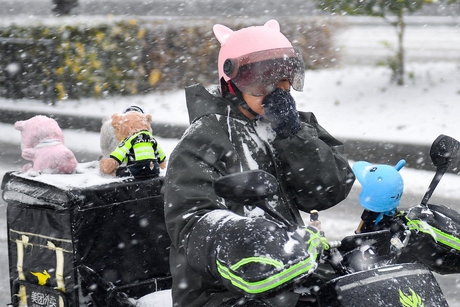 11月6日，在長春市街頭，一名外賣員在雪中騎行。新華社記者 許暢 攝
