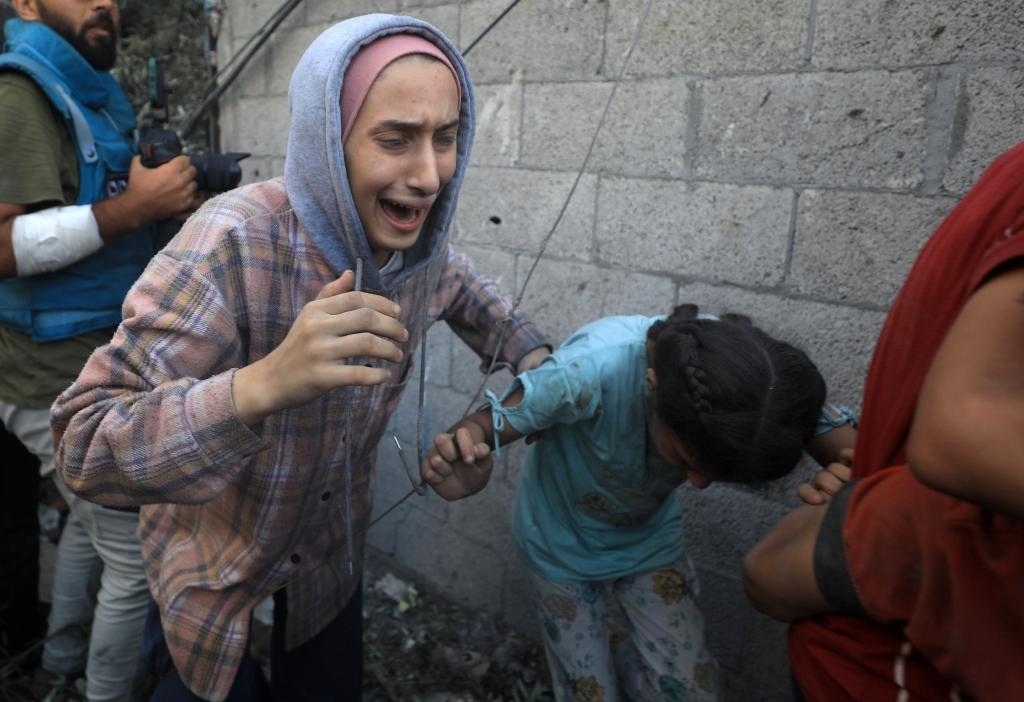 11月6日，人們從加沙地帶中部地區(qū)一處被炸難民營逃離。新華社發(fā)（亞西爾·庫迪攝）