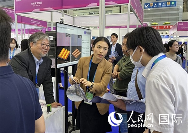 工作人員向參觀者介紹超級(jí)噴墨技術(shù)。（人民網(wǎng)記者 陳思攝）