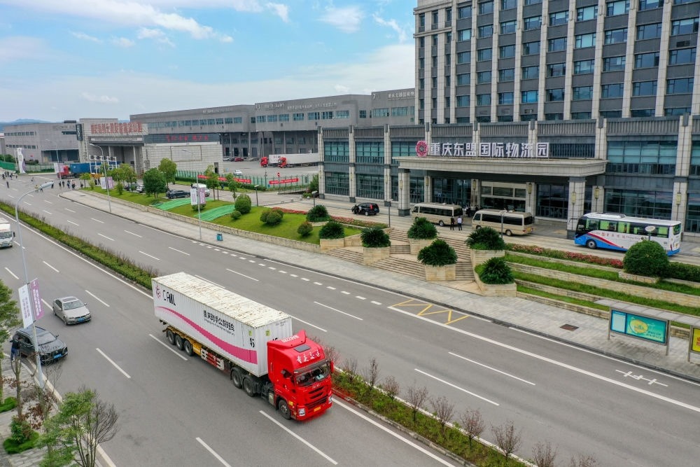 2023年10月11日，滿載筆記本電腦配件、發(fā)電機組件等產品的西部陸海新通道跨境公路班車從重慶南彭公路保稅物流中心駛出，將途經廣西憑祥，直達越南（無人機照片）。新華社記者 黃偉 攝