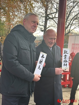 柏林市長韋格納（右）、動(dòng)物園監(jiān)事會(huì)主席布魯克曼（左）手持中國文化中心工作人員現(xiàn)場(chǎng)手書的中文名字。人民網(wǎng)記者 徐馨攝