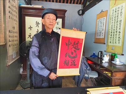 越南首都河內(nèi)文廟內(nèi)，阮明珠展示“中越心相近”書法作品。