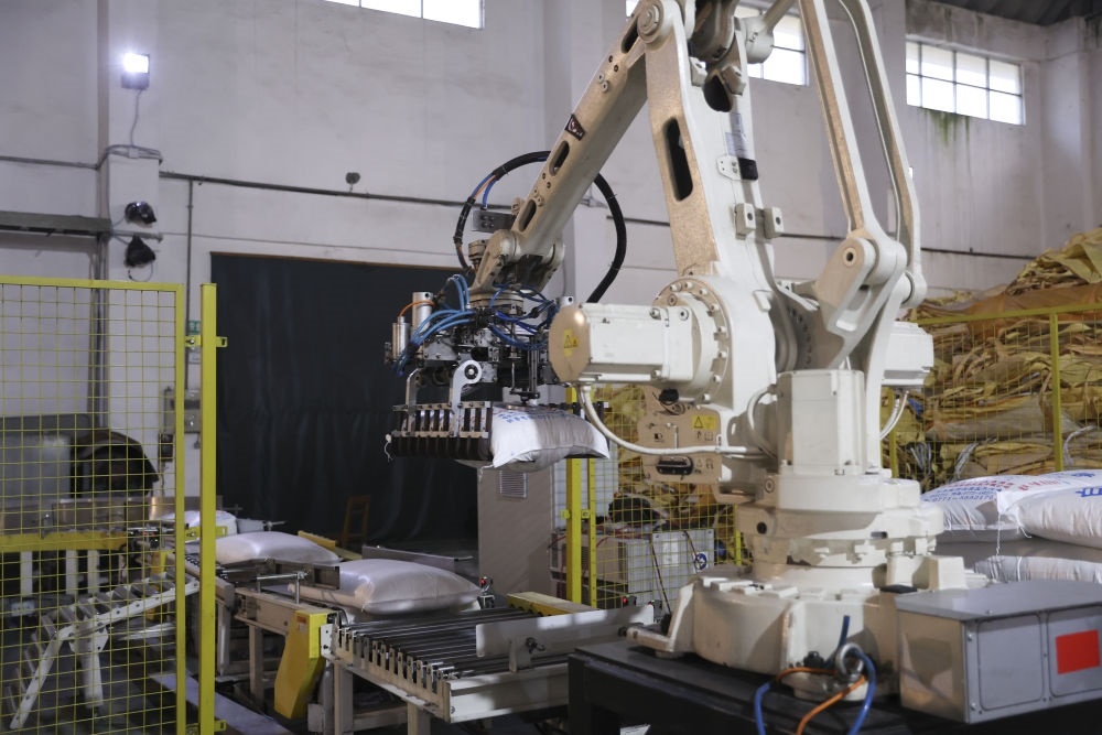 12月14日，在廣西來(lái)賓東糖鳳凰有限公司，機(jī)械臂在廠房碼放白砂糖成品。