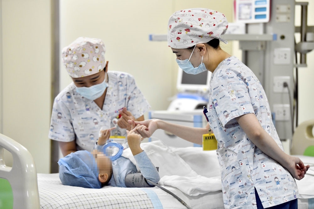 在山東省棗莊市婦幼保健院兒童ICU病房，醫(yī)護人員為完成靶向治療藥物諾西那生鈉的4歲脊髓性肌萎縮癥患兒加油鼓勁（2022年1月1日攝）。諾西那生鈉注射液是我國首個獲批治療脊髓性肌萎縮癥的進口藥物，2019年進入中國市場時，每針價格近70萬元。在2021年國家醫(yī)保目錄藥品談判中，以3.3萬元每針的價格進入新版醫(yī)保藥品目錄。新華社記者 郭緒雷 攝