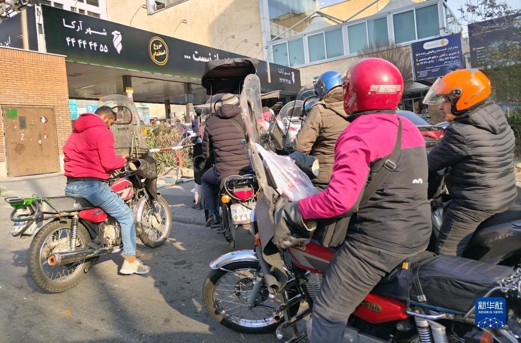 12月18日，摩托車在伊朗首都德黑蘭的一家加油站外等待加油。新華社記者 沙達(dá)提 攝
