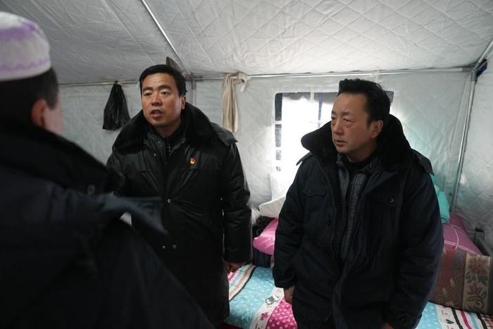 2023年12月22日，積石山縣大河家鎮(zhèn)大河村黨支部書記馬成忠（右二）在帳篷里和受災(zāi)群眾交流。新華社記者 陳斌 攝