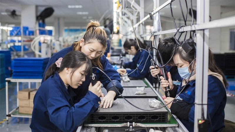 在新亞勝光電的產(chǎn)品線上，工人正進(jìn)行產(chǎn)品組建和安裝布線。受訪者供圖