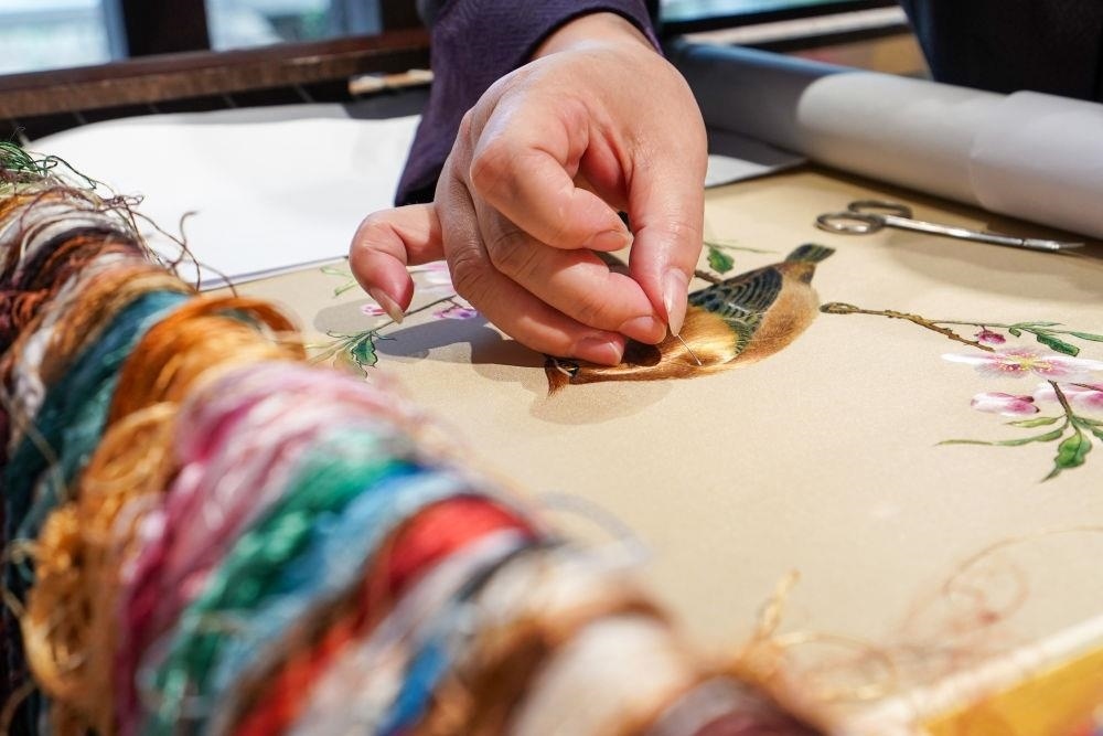 △2023年7月6日，盧建英在江蘇蘇州平江路的工作室內(nèi)刺繡。