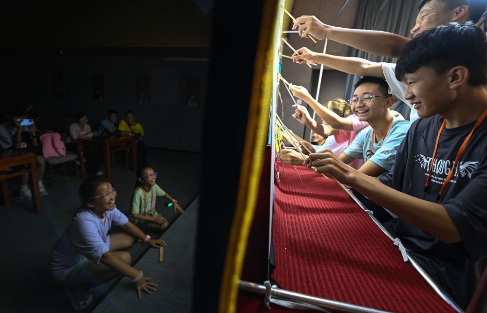 2023年8月8日，進(jìn)行暑期研學(xué)的學(xué)生在位于陜西省西安市的中國(guó)秦腔藝術(shù)博物館體驗(yàn)皮影戲演出。新華社記者 鄒競(jìng)一 攝