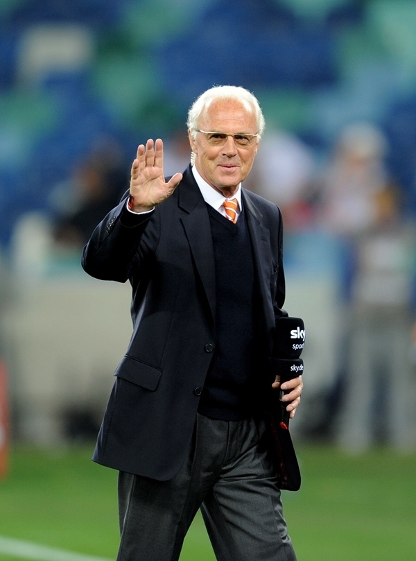 這是2010年7月7日，在南非德班舉行的2010年足球世界杯德國(guó)隊(duì)對(duì)陣西班牙隊(duì)的半決賽前，貝肯鮑爾接受電視臺(tái)采訪時(shí)和友人打招呼。新華社記者 王毓國(guó) 攝