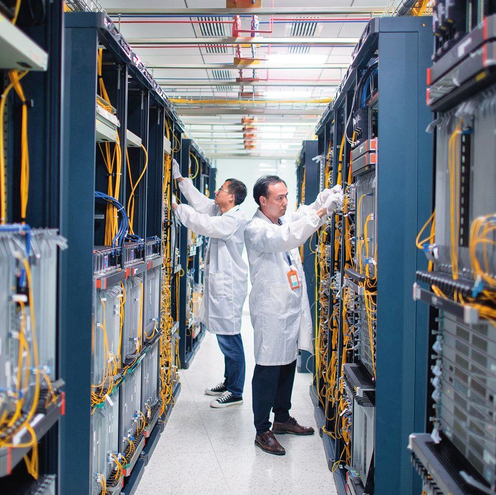 在位于武漢中國(guó)光谷的光電器件研發(fā)制造商——武漢光迅科技股份有限公司生產(chǎn)車(chē)間內(nèi)，技術(shù)人員在光模塊生產(chǎn)線作業(yè)（2023年4月11日攝）。程敏攝/本刊