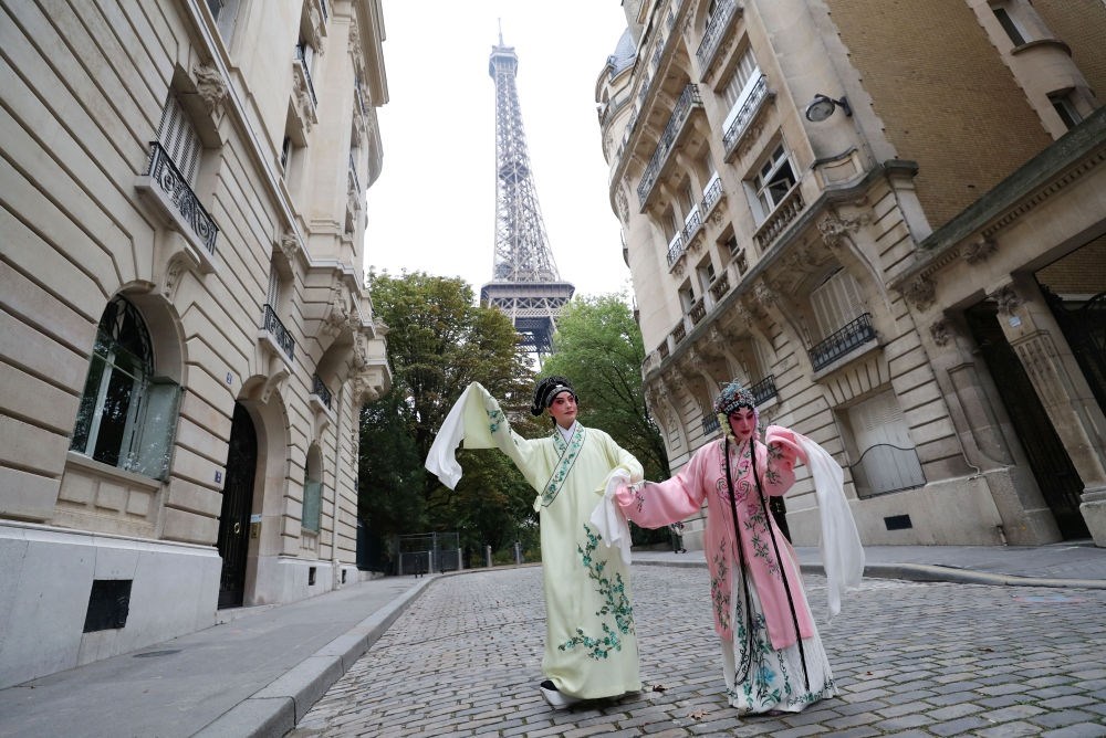 2023年9月13日，江蘇省演藝集團(tuán)昆劇院院長(zhǎng)施夏明（左）和江蘇省演藝集團(tuán)昆劇院國(guó)家一級(jí)演員孔愛(ài)萍在法國(guó)巴黎埃菲爾鐵塔附近參加昆曲快閃。新華社記者 高靜 攝