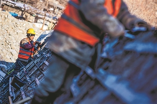 1月3日，房山區(qū)，工人正在雙泉河修筑堤壩。