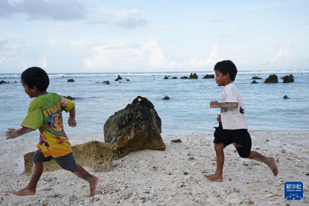 1月20日，兒童在瑙魯海邊嬉戲。新華社記者 王申 攝