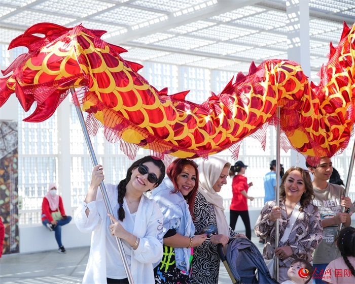 游客體驗(yàn)舞龍。 人民網(wǎng) 塔里克·易卜拉欣攝