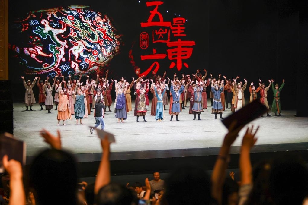 2023年7月31日，新疆和田地區(qū)新玉歌舞團(tuán)在烏魯木齊京劇院演出舞劇《五星出東方》后和觀眾互相揮手致意。這場演出是第六屆中國新疆國際民族舞蹈節(jié)的參演劇目之一，曾榮獲國家“文華獎”等。新華社記者 郝昭 攝