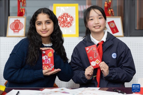 1月28日，美國馬斯卡廷中學(xué)學(xué)生（左）和復(fù)旦大學(xué)第二附屬學(xué)校學(xué)生展示互相送出的寫有寄語祝福的紅包。 新華社記者 王翔 攝