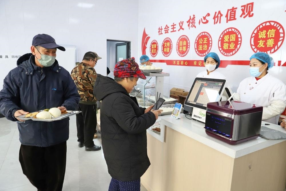 △2024年2月1日，市民在河北涿州市雙塔街道永濟秀園小區(qū)便民食堂內(nèi)購買午餐。