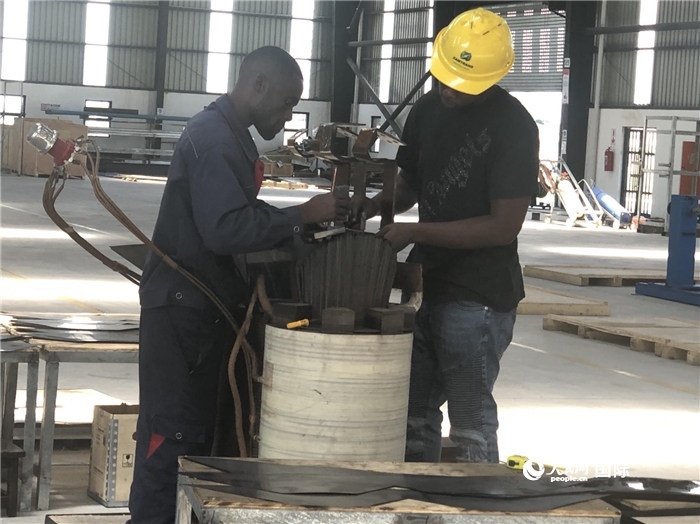 經(jīng)貿(mào)合作區(qū)廠房?jī)?nèi)，當(dāng)?shù)毓と苏诰o張作業(yè)。人民網(wǎng)記者 黃培昭攝