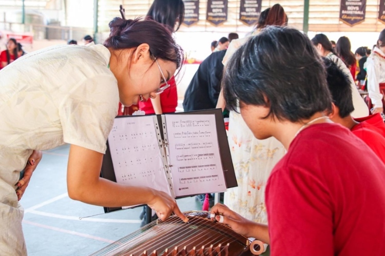 志愿者教師指導(dǎo)學(xué)生彈奏古箏?；顒?dòng)主辦方供圖