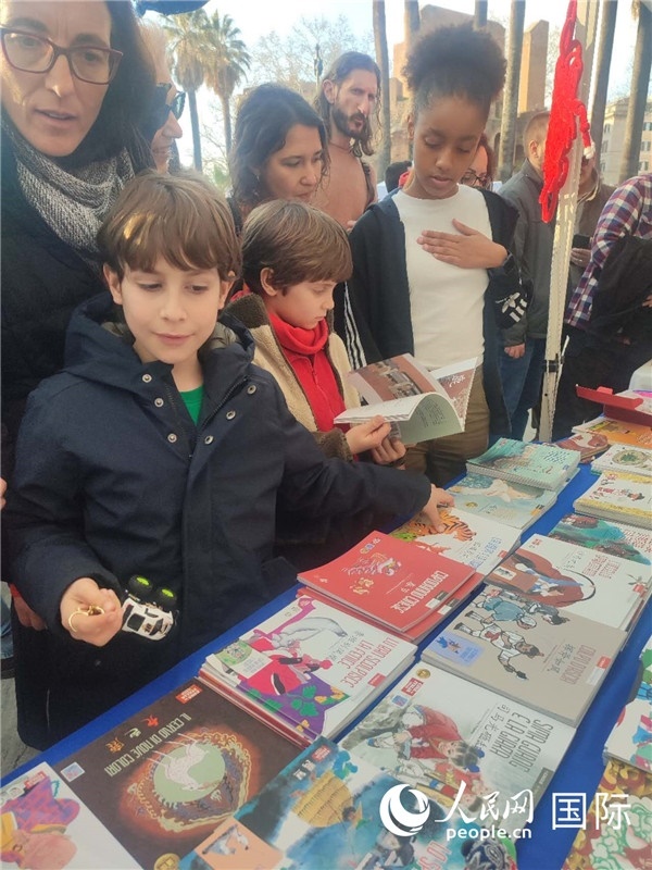 印刷精美的中國(guó)傳統(tǒng)文化叢書吸引了小游客的注意。人民網(wǎng)記者鄭彬攝