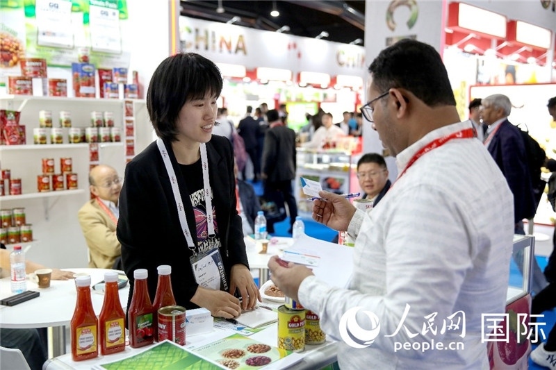 圖為中國參展企業(yè)代表與采購商交流。人民網(wǎng) 塔里克·易卜拉欣攝