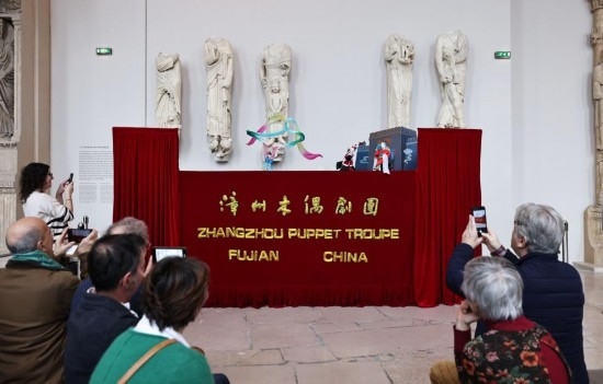 2月10日，在位于法國(guó)巴黎埃菲爾鐵塔附近的“建筑與遺產(chǎn)之城”博物館，觀眾欣賞漳州布袋木偶戲。新華社記者高靜攝