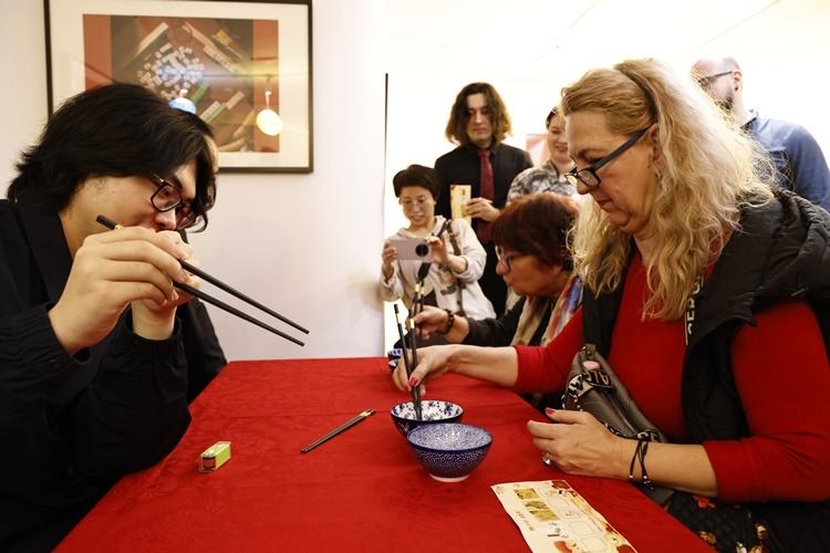 羅馬尼亞觀眾體驗用筷子夾花生。中國文化中心供圖