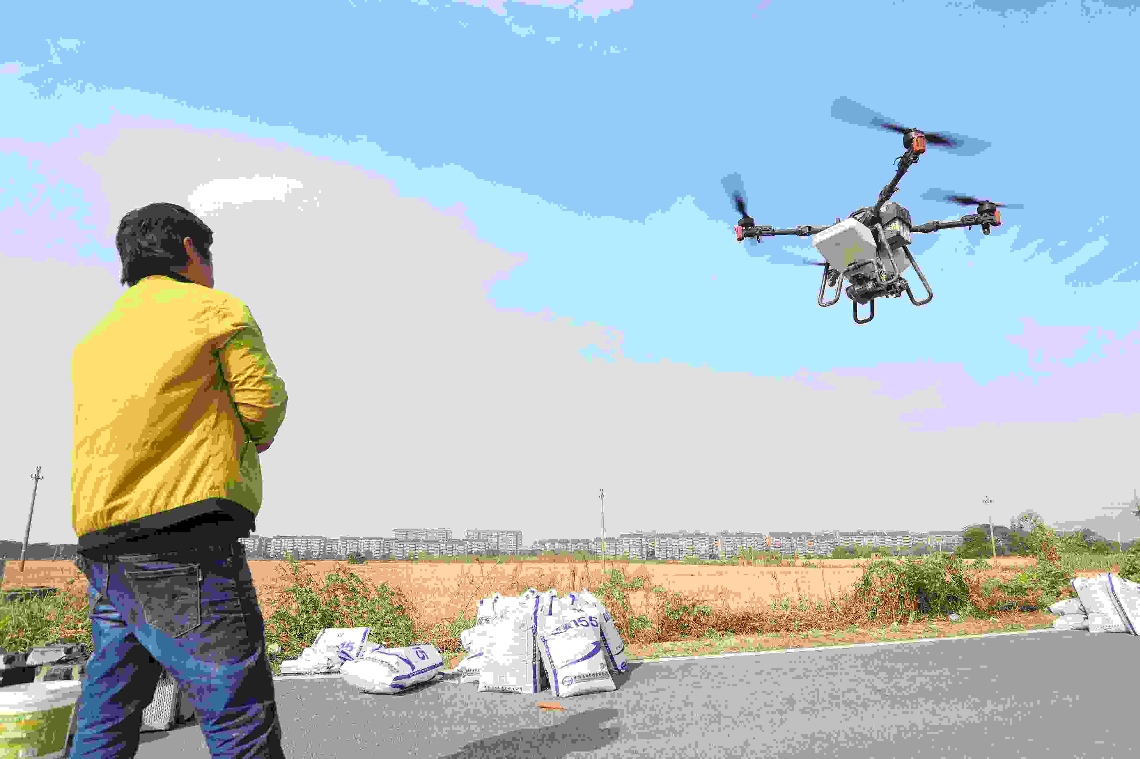 2023年11月15日，浙江嘉興，南湖區(qū)七星街道一處農(nóng)田里，農(nóng)民操縱無人機進行冬小麥飛播。