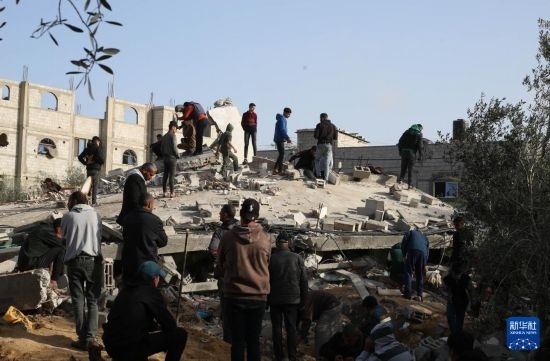  3月3日，在加沙地帶南部城市拉法，人們查看被以軍空襲破壞的建筑。新華社發(fā)（哈立德·奧馬爾攝）