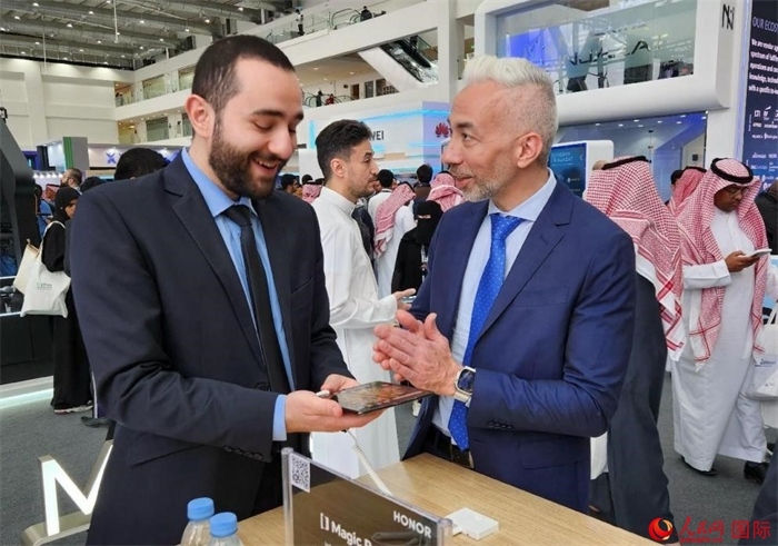 兩名觀眾在榮耀手機(jī)展臺前交流。人民網(wǎng)記者 管克江攝