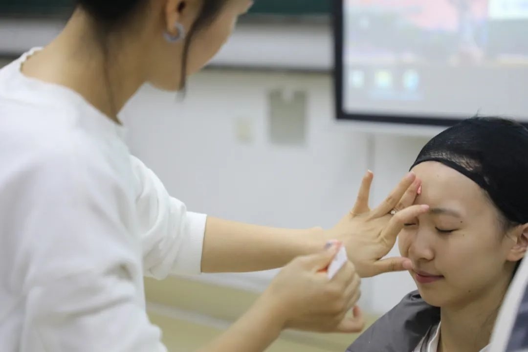 課堂上，一名學生在體驗上戲妝。學校供圖