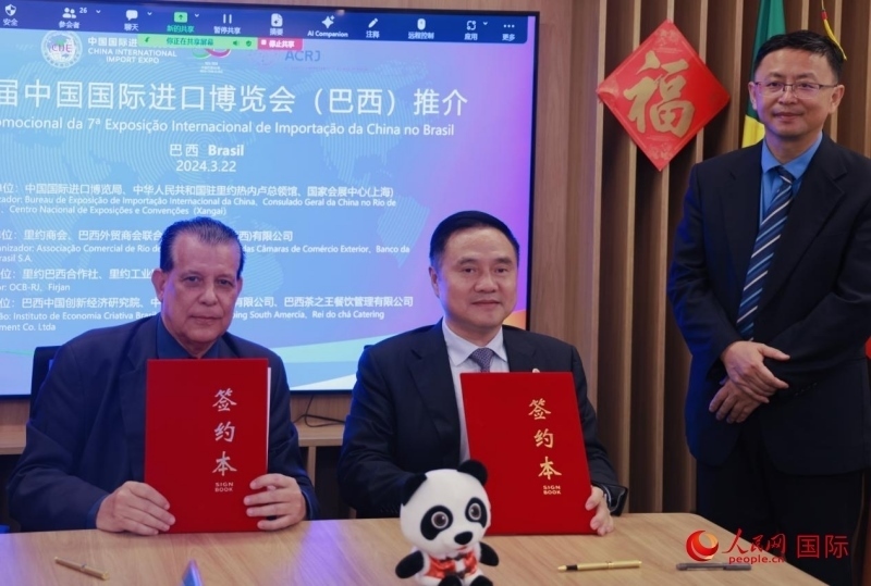 巴西外貿(mào)商會(huì)聯(lián)合會(huì)會(huì)長阿代爾·羅伯托（左）與中國國際進(jìn)口博覽局副局長吳政平（中）現(xiàn)場(chǎng)簽訂協(xié)議。人民網(wǎng)記者 宋亦然攝