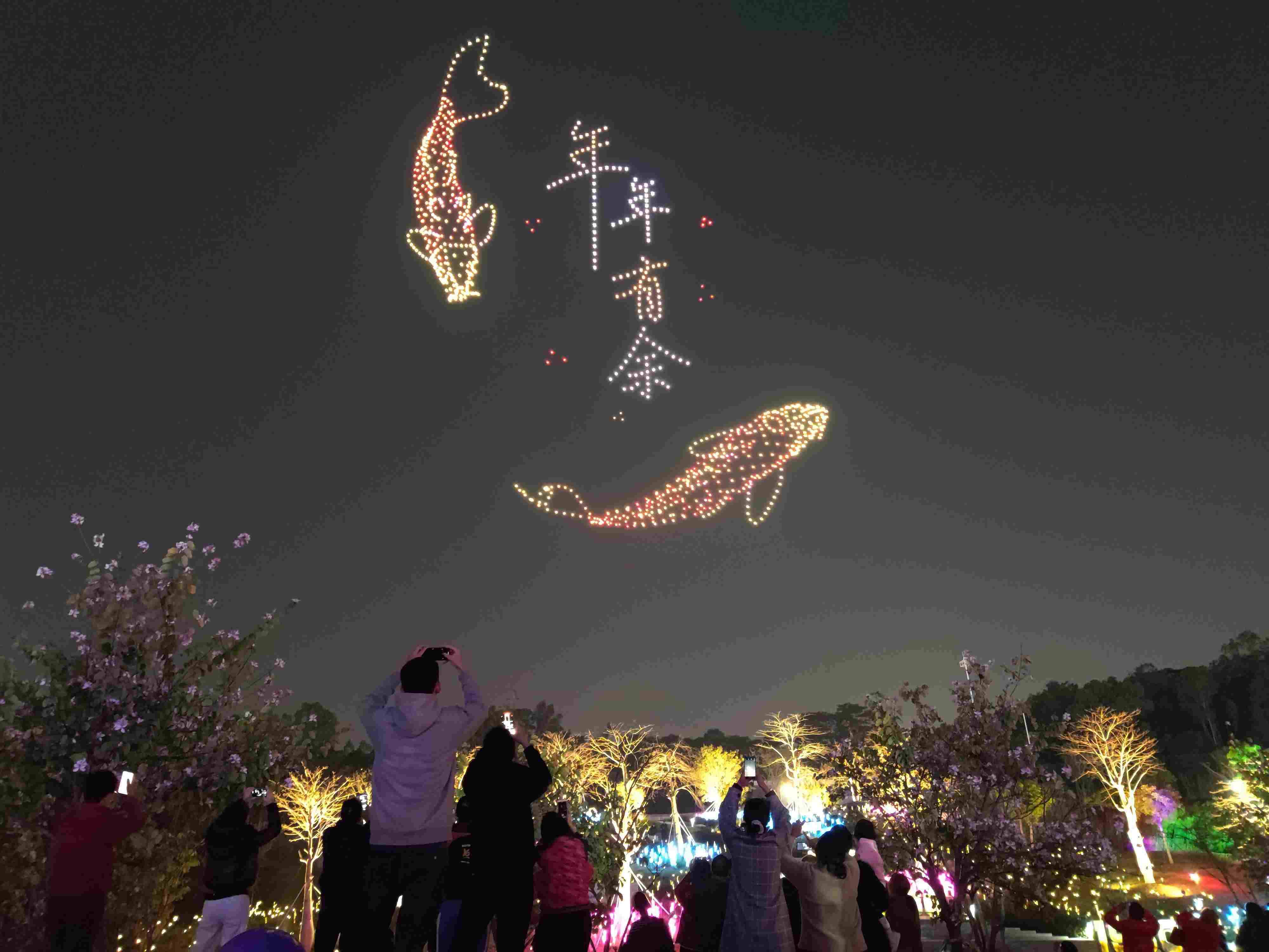 △ 2024年2月10日，深圳北站中心公園，春節(jié)主題無人機(jī)燈光秀引來眾多游客駐足觀看。