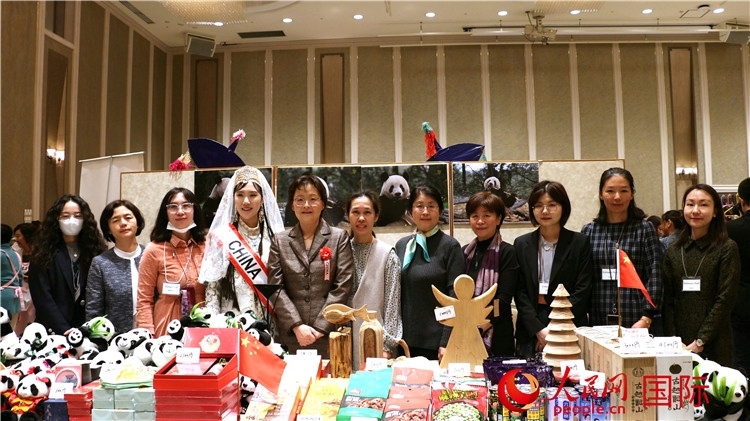 中國駐日本大使吳江浩夫人丁玥（左五）與使館人員在展位前合影留念。人民網(wǎng) 許可攝