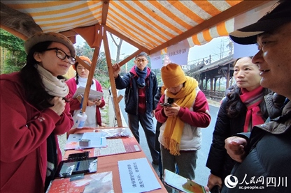 1月6日，“2024成都蒲江柑甜采摘節(jié)”上，記者見到了小萌（左一）和許多年輕人忙著做訪客接待、現(xiàn)場布置、票務(wù)核對、采摘服務(wù)等工作。人民網(wǎng)記者朱虹攝