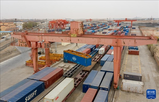 4月21日，二連浩特鐵路口岸龍門吊吊裝中歐班列集裝箱（無(wú)人機(jī)照片）。 新華社發(fā)（張海峰攝）