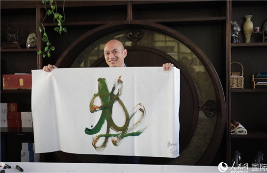 老撾駐華大使館三秘明君參加《五百筆·瀾湄合作》集體藝術(shù)創(chuàng)作。人民網(wǎng)王婧攝。