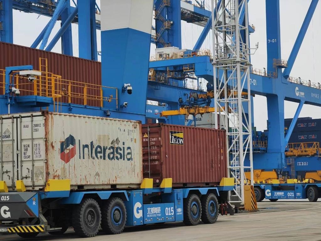 在欽州自動化集裝箱碼頭，智能導(dǎo)引運(yùn)輸車在運(yùn)送集裝箱。新華社記者趙歡 攝