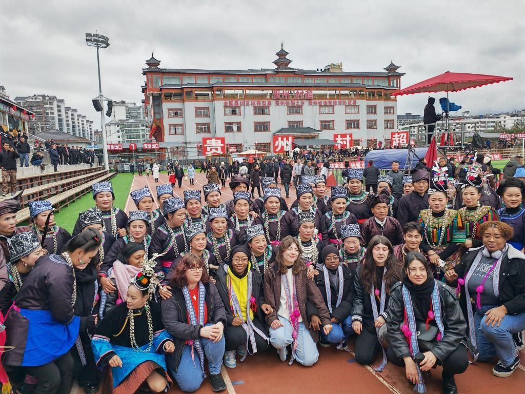 法國青年在“村超”賽場邊與參加表演的村民合影。新華社記者 羅羽 攝