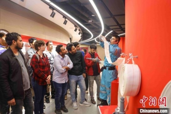 5月9日，工作人員指導(dǎo)留學(xué)生正確使用消防水帶。張鷹 攝