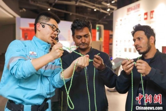 5月9日，工作人員指導(dǎo)留學(xué)生學(xué)習(xí)打繩結(jié)。張鷹 攝